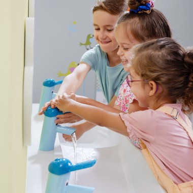 Niños jugando en el espacio de juegos y lavado Geberit Bambini