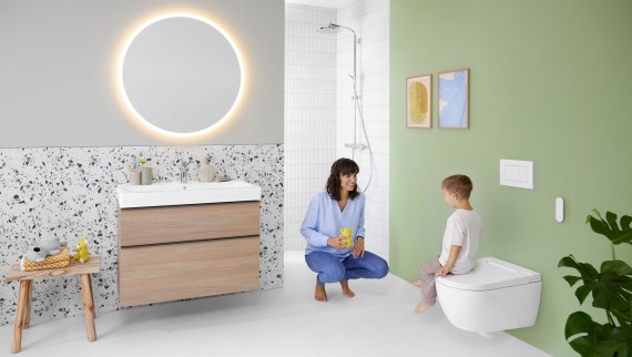 Mujer y niño en un baño con inodoro bidé Geberit AquaClean Alba