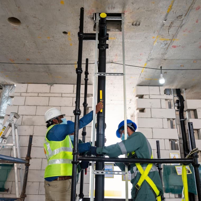 Los técnicos colocan la bajante en su lugar Los técnicos colocan la bajante en su lugar