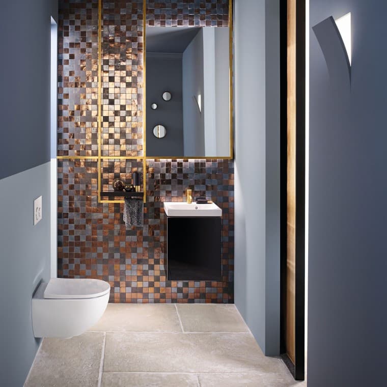Vista de un baño de invitados moderno con un inodoro y un lavabo Acanto frente a una pared con mosaico Vista de un baño de invitados moderno con un inodoro y un lavabo Acanto frente a una pared con mosaico