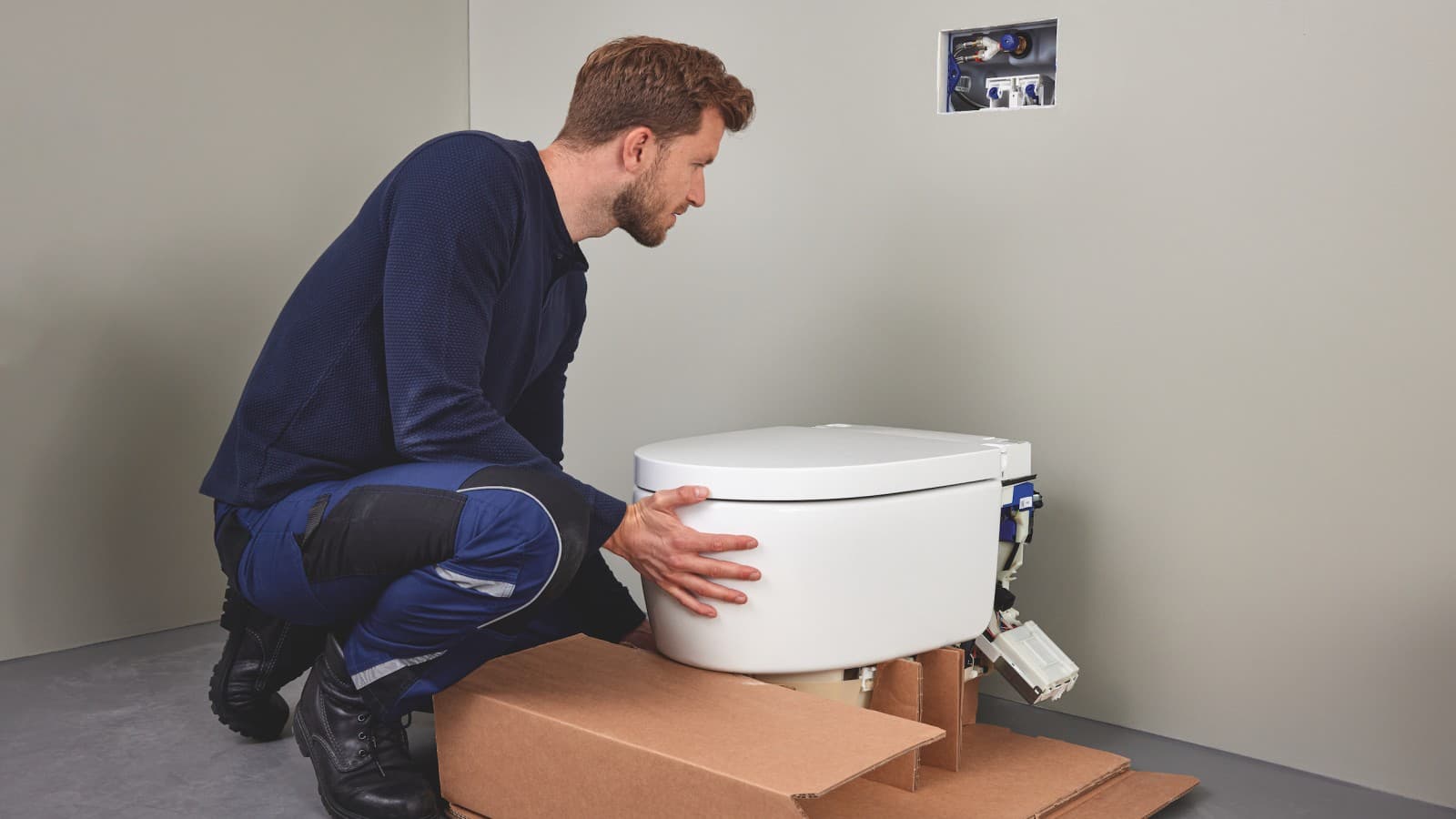Un profesional sanitario instala un inodoro bidé Geberit AquaClean Sela Un profesional sanitario instala un inodoro bidé Geberit AquaClean Sela