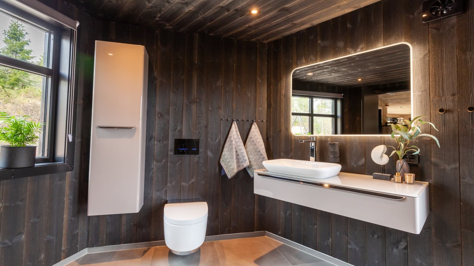 El baño también está revestido de madera y, además del inodoro bidé AquaClean Mera, hay otros productos Geberit instalados en él (© Geberit) El baño también está revestido de madera y, además del inodoro bidé AquaClean Mera, hay otros productos Geberit instalados en él (© Geberit)